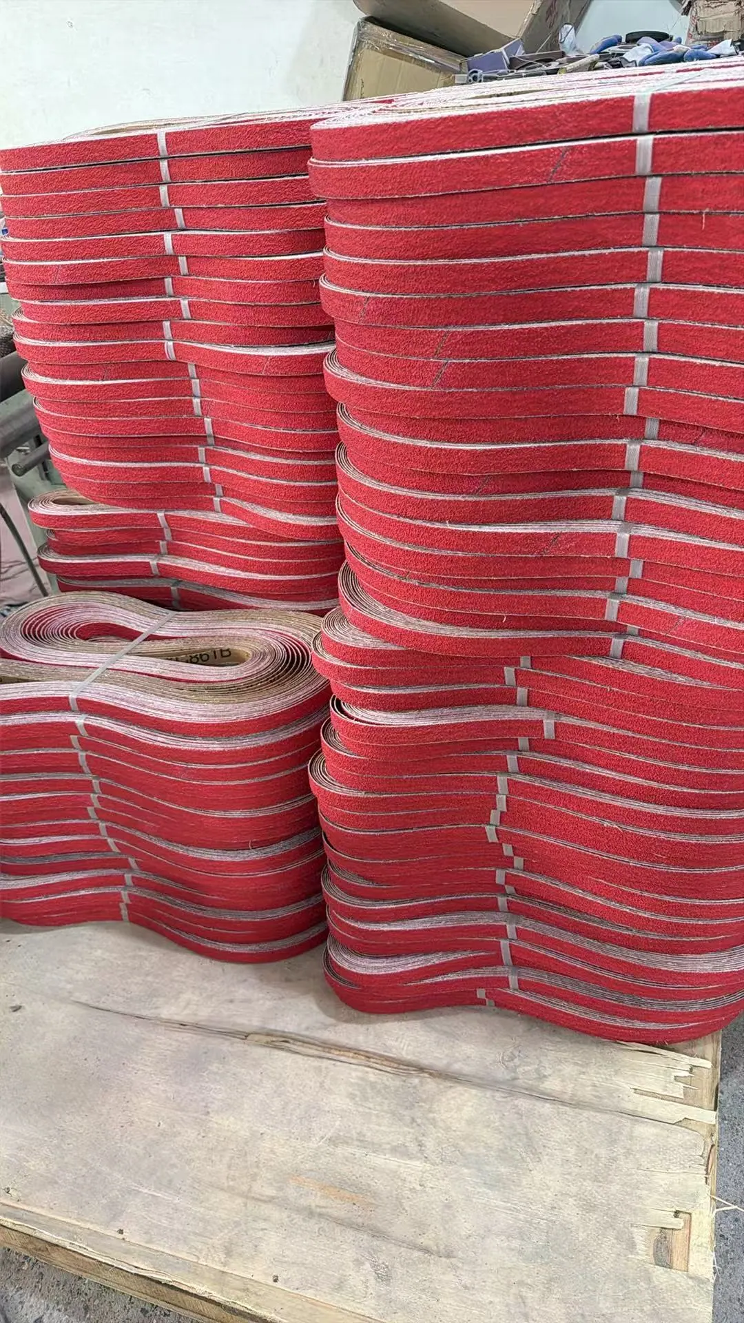 Red custom-size sanding belts prepared in production batches